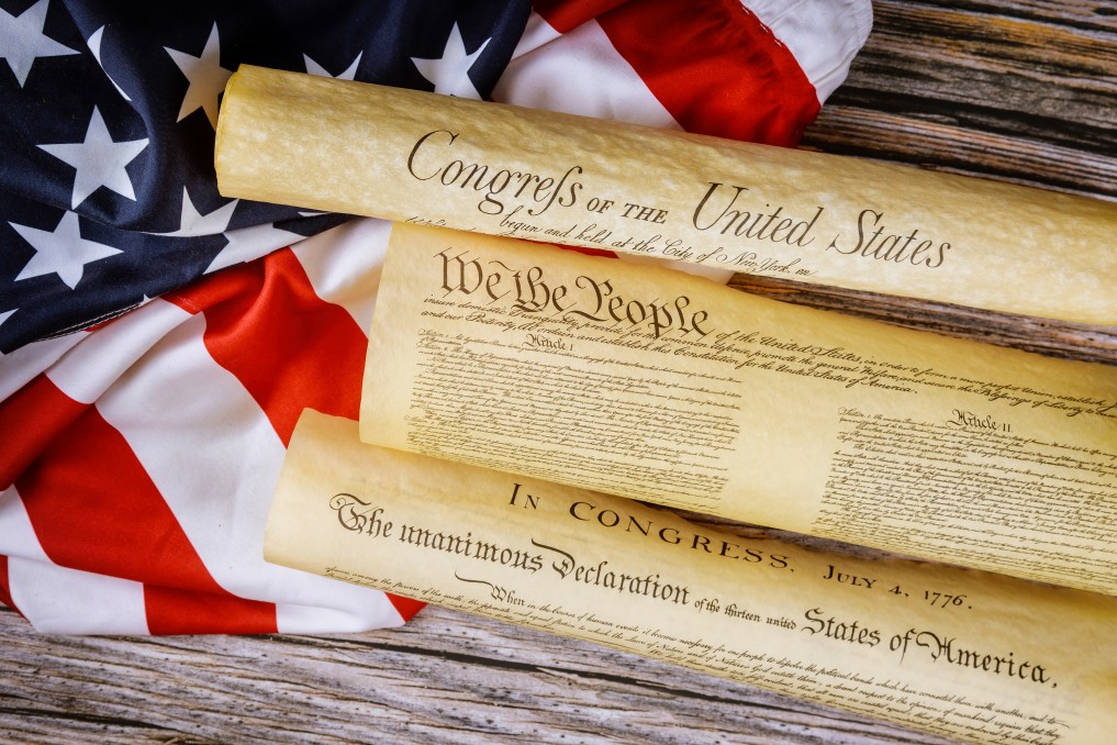 Closeup of a replica of the United States document of American Constitution with We the People and the USA flag